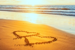 Valentines day on sunny beach. Two hearts drawn in sand, love concept